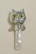 A sterling silver baby's rattle in the form of a cat's head with a mother of pearl style handle, 3"