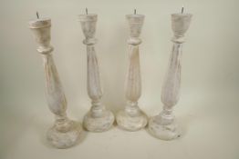 A set of four turned wood pricket candlesticks with distressed paint finish, 18" high