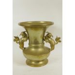 A brass vase with flared neck and two cast fo dog handles, 11" high