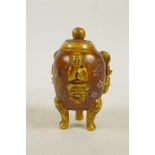 A Peking glass censer and cover on tripod supports with three raised and gilt depictions of Buddha