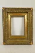 A good C19th gilt composition picture frame with raised leaf and corner ribbon decoration, 9¼" x 6½"