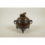 A Chinese bronze barrel shaped censer on elephant head tripod supports and two elephant mask