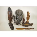 A collection of African carved hardwood masks, figures and pourer, and two Asian carved hardwood