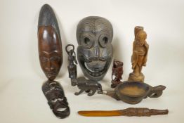 A collection of African carved hardwood masks, figures and pourer, and two Asian carved hardwood