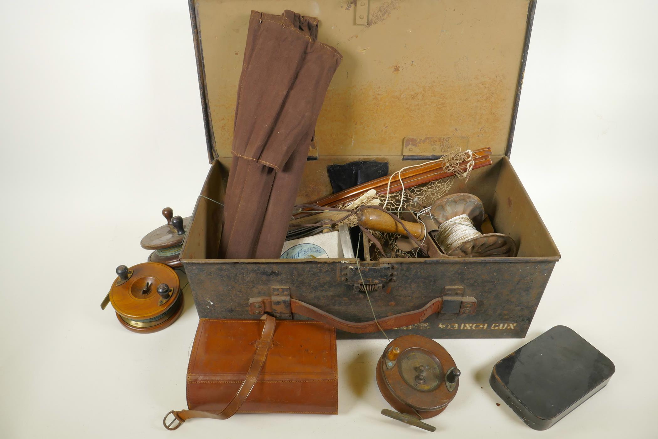 An ammunition box containing a quantity of vintage fishing equipment including wood and brass