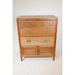 A stripped oak chest of drawers with brass military handles, two short over two long drawers and a