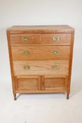 A stripped oak chest of drawers with brass military handles, two short over two long drawers and a