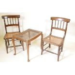 A pair of mahogany, cane seated spindle back side chairs, and a walnut footstool with a cane seat