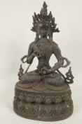 A Chinese bronze figure of Quan Yin seated in meditation on a double lotus throne, 15" high