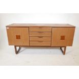 A 1970s Europa furniture sideboard with two cupboards flanking a flight of four drawers, 59" x