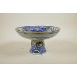 A Chinese wucai porcelain stem bowl decorated with a phoenix and kylin, 5" high x 8½" diameter