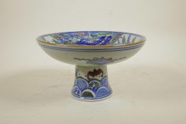 A Chinese wucai porcelain stem bowl decorated with a phoenix and kylin, 5" high x 8½" diameter