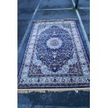 A Turkish blue ground full pile carpet with floral medallion decoration on a red field, 79" x 118"