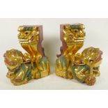 A pair of carved giltwood fo dogs with hawks on their backs, 10" high