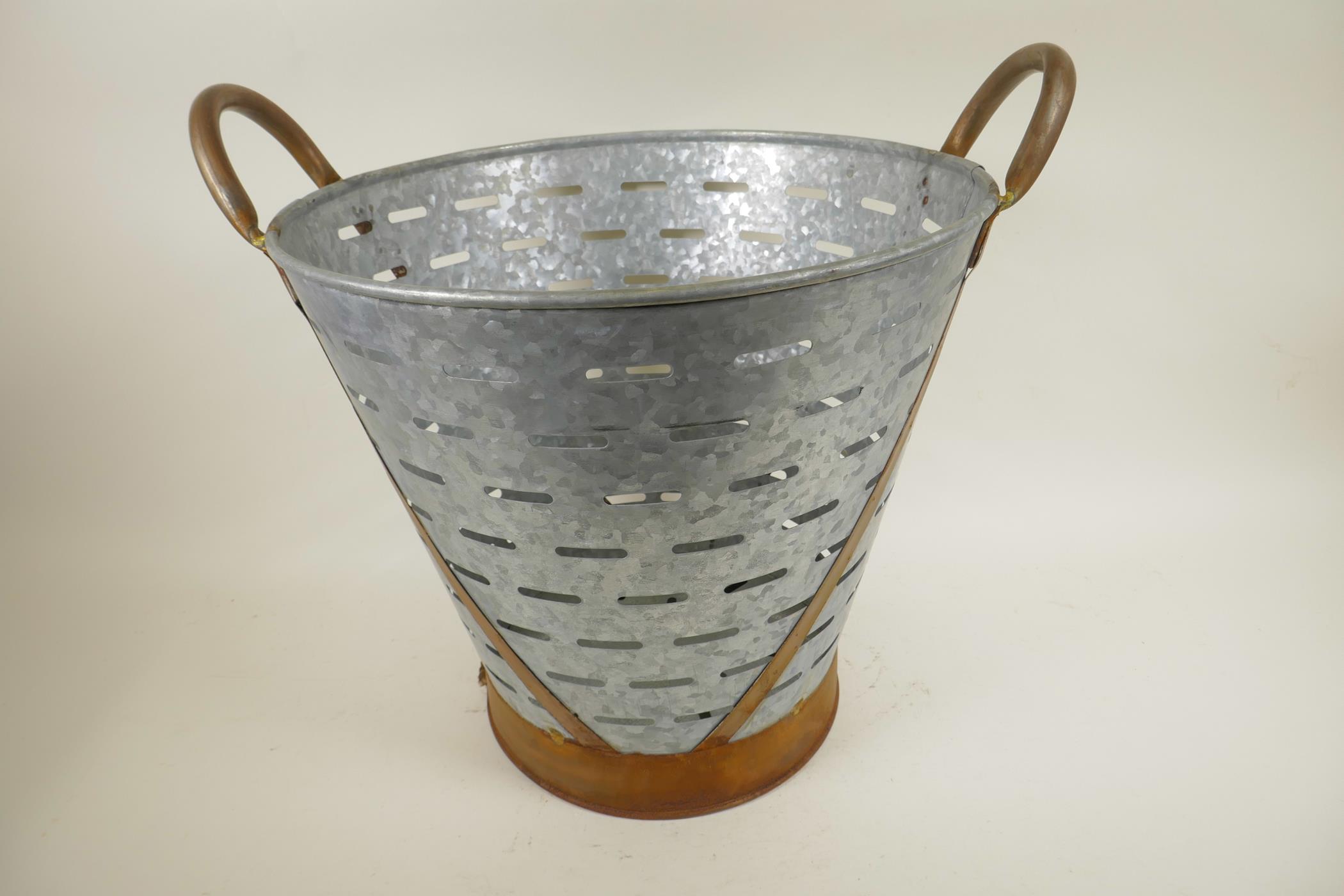 A galvanised iron olive bucket with copper loop handles, 16" diameter