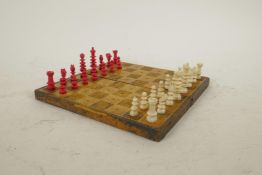 A leather bound travel chess set with turned and dyed bone pieces, one pawn missing, 7" x 7"