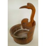 An African coopered hardwood laundry bowl, the handle carved as a stork, 17" diameter, 22" high
