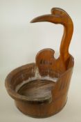 An African coopered hardwood laundry bowl, the handle carved as a stork, 17" diameter, 22" high