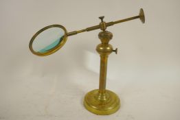 An adjustable, brass table top magnifying glass, lens 4" diameter
