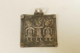 A Javan white metal pendant with repousse figural decoration, 2" wide