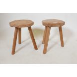 A pair of blond oak milking stools, 13" high