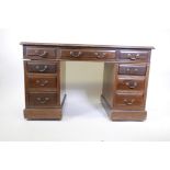 An Edwardian walnut nine drawer twin pedestal desk with swan neck handles, 29" x 48" x 26"