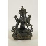 A Sino-Tibetan bronze of a female deity seated on a lotus throne, 8" high