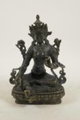 A Sino-Tibetan bronze of a female deity seated on a lotus throne, 8" high