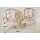A pair of Louis style armchairs with floral upholstery and distressed paint finish