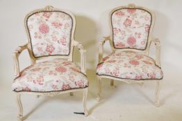 A pair of Louis style armchairs with floral upholstery and distressed paint finish