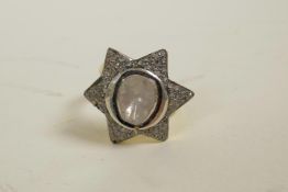 A silver gilt dress ring in the form of a star, encrusted with uncut diamonds