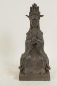 A Chinese bronze figure of Guan Yin seated on a plinth decorated with calligraphy, 9½" high