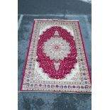 A Kashmiri red ground rug with an unique floral medallion design, 61½" x 91"