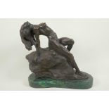 A stylised bronze figure of a nude female posed on a rock, 11" high
