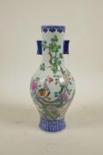 A Chinese polychrome porcelain vase with two lug handles, decorated in enamels depicting Asiatic