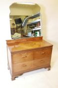 An Art Deco three quarter veneered walnut dressing table with mirror back, two short drawers over