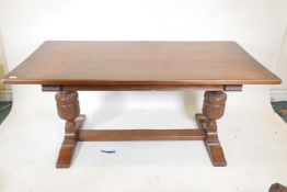 A plank top oak refectory table with bulbous carved end supports, 66" x 33½", 30" high