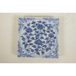 A Chinese blue and white porcelain temple tile with floral decoration, 7½" x 7½"