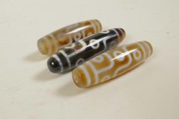 Three Tibetan agate dzi beads, longest 2½"