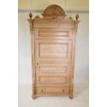 A Continental pine single door armoire, with a single drawer to base, raised on turned supports,
