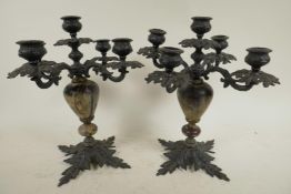 A pair of iron and lacquer leaf pattern four branch, five light candelabra, 10½" high