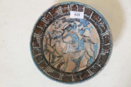 A Middle Eastern terracotta bowl decorated with stylised Islamic text, and huntsman with hawk and