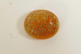 An Islamic amber agate token/counter with engraved and gilt calligraphic inscription, 1"