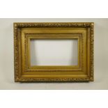 A C19th gilt composition picture frame with raised leaf and flower decoration, 15¾" x 9½" aperture