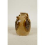A Chinese pottery wine jug with two lug handles and raised and glazed grapevine decoration, 4" high