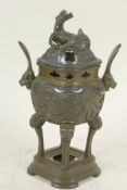An Oriental bronze censer raised on four kylin headed legs, the body embossed with a phoenix and the