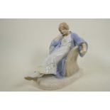 A Royal Copenhagen porcelain figurine of a lady sleeping in a wicker chair, marked with numbers