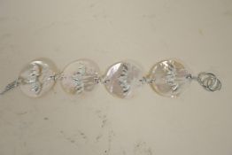 A mother of pearl and silver bracelet made as four mother of pearl discs set with silver bats, 8"