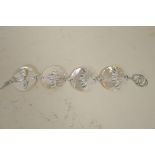 A mother of pearl and silver bracelet made as four mother of pearl discs set with silver bats, 8"