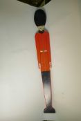 A painted wood height measure in the form of a guard in ceremonial dress including busby, 48" high